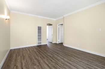 an empty living room with wood flooring and white walls